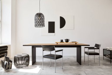 Tasarım ahşap aile masası, siyah sandalyeler, fincanlı çaydanlık, duvarda sanat resimleri ve modern ev dekorunda zarif aksesuarları olan şık bir yemek odası. Şablon.