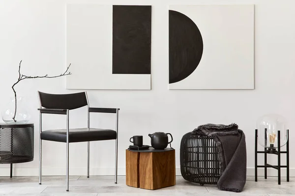 Modern composition of living room interior with design black chair, wooden cube, rattan pouf, commode , lamp, mock up art paintings and elegant accessoreis in stylish home decor.