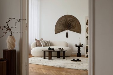 Dekoratif duvar sanatı ve minimalist mobilyaları olan tarafsız bir oturma odası.