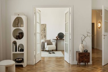 Minimalist yaşam alanı, sanatsal dekor ve klasik kamera ile açık kapılar ardında görünüyor.