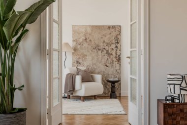 Parlak bir köşede zarif bir koltuk, desenli soyut bir tablo ve sıcak tekstil..