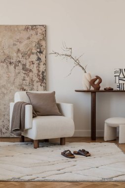 Modern iç mimari bir vazo, minimalist sanat eserleri ve doğal tonda ahşap bir sandalye..