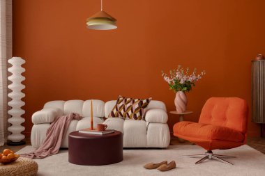 Tasarım kanepesi, dekorasyonu ve ev aksesuarlarıyla oturma odasının şık turuncu iç mekanı.. 