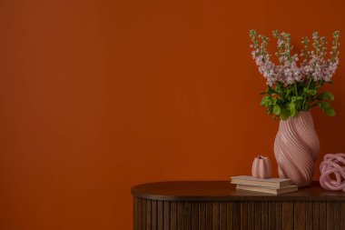 Ahşap dolapta portakal rengi kompozisyonlar, modern vazo ve çiçek aksesuarları. Boşluğu kopyala.