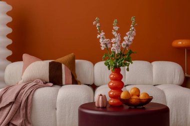 Minimalist yaşam alanı, heykel desenli çiçekler ve turuncu ve nötr renklerle modern dekorasyonlar.