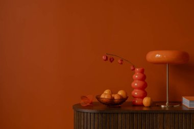 Portakallı bir büfeye yakın çekim, kalın kırmızı lamba ve turuncu bir duvara seramik vazolar. Boşluğu kopyala. 