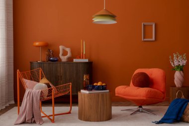 Modern tel sandalyeli, turuncu tonları ve yumuşak mobilyaları olan eklektik oturma odası. Geometrik kontrastlı sıcak ve canlı bir ortam.