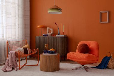 Yüzyılın ortalarında mobilya, heykel parçaları ve minimalist ışıklandırması olan portakal renkli bir duvar. Cesur, dengeli ve rahat..