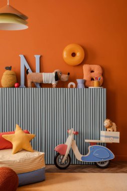 Oyuncak scooter, pastel harfler, çocuk koltuğu ve peluş hayvanlardan oluşan renkli çocuk alanı.