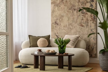 Zarif bir iç köşe zeytin koltuğu, şık bir lamba, duvarda sanat eserleri ve sıcak doğal ışık. Yumuşak ve modern.