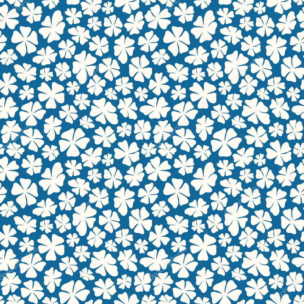 Hand drawn ditsy white flowers on a blue background in a tossed seamless pattern. Pretty floral vector design perfect for fabric and backgrounds.