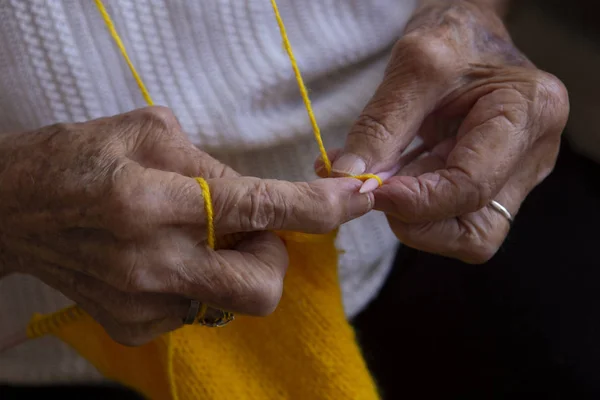 Mãos de uma velha mulher agulhas de tricô — Fotografia de Stock