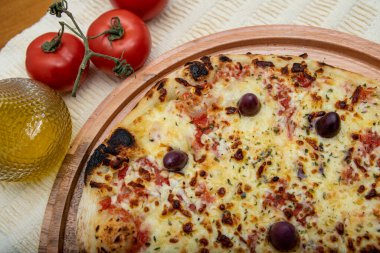 Zeytin yağı ve domateslerle süslenmiş ahşap masada mozzarela peynirli pizza. Pizza margarita.