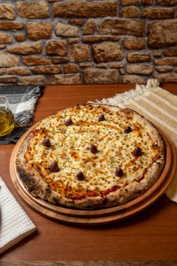 Tahta bir tahtanın üzerinde servis edilen Pizza Tavuk Katupiry aroması. Mozzarella, tavuk, krem peynirli, zeytinli ve kırmızı domates soslu. Bir bardak zeytinyağı. Geleneksel Brezilya pizzası. Metin için boşluk