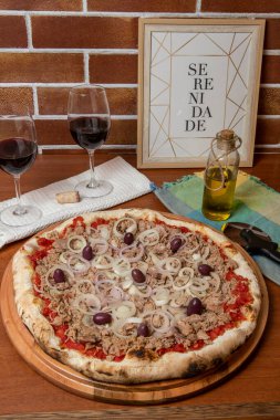 Pizza ton balığı, soğan, domates ve ahşap masada siyah zeytin. Geleneksel Brezilya Pizzası. Portekizce metin: dinginlik