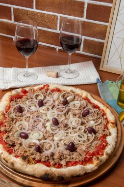 Pizza ton balığı, soğan, domates ve ahşap masada siyah zeytin. Geleneksel Brezilya Pizzası.