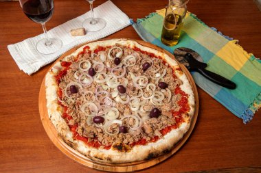 Pizza ton balığı, soğan, domates ve ahşap masada siyah zeytin. Geleneksel Brezilya Pizzası.