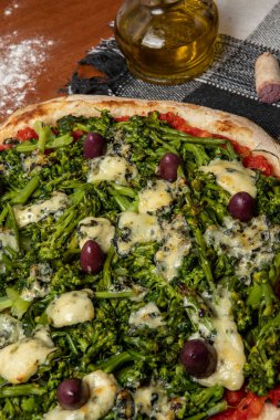 Brokoli, gorgonzola peyniri, siyah zeytin, sarımsak ve domates soslu pizza.