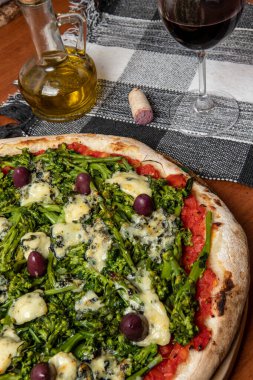 Brokoli, gorgonzola peyniri, siyah zeytin, sarımsak ve domates soslu pizza.