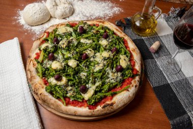 Brokoli, gorgonzola peyniri, siyah zeytin, sarımsak ve domates soslu pizza.