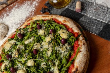 Brokoli, gorgonzola peyniri, siyah zeytin, sarımsak ve domates soslu pizza.