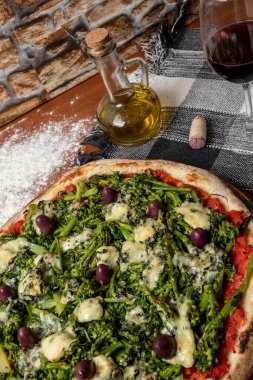 Brokoli, gorgonzola peyniri, siyah zeytin, sarımsak ve domates soslu pizza.