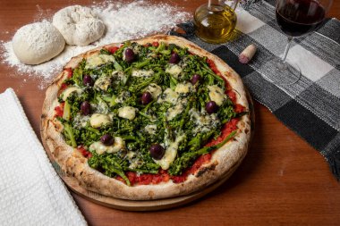 Brokoli, gorgonzola peyniri, siyah zeytin, sarımsak ve domates soslu pizza.