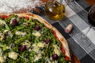 Brokoli, gorgonzola peyniri, siyah zeytin, sarımsak ve domates soslu pizza.