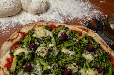 Brokoli, gorgonzola peyniri, siyah zeytin, sarımsak ve domates soslu pizza.