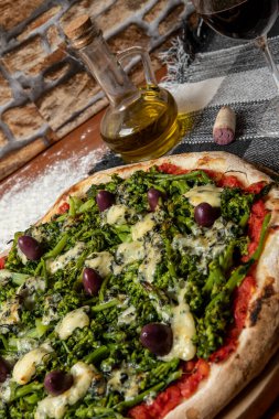 Brokoli, gorgonzola peyniri, siyah zeytin, sarımsak ve domates soslu pizza.