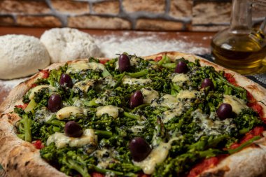 Brokoli, gorgonzola peyniri, siyah zeytin, sarımsak ve domates soslu pizza.