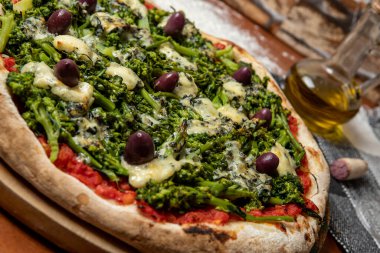 Brokoli, gorgonzola peyniri, siyah zeytin, sarımsak ve domates soslu pizza.