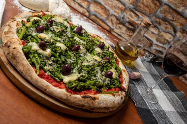 Brokoli, gorgonzola peyniri, siyah zeytin, sarımsak ve domates soslu pizza.