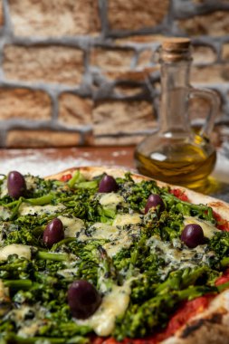 Brokoli, gorgonzola peyniri, siyah zeytin, sarımsak ve domates soslu pizza.