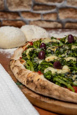 Brokoli, gorgonzola peyniri, siyah zeytin, sarımsak ve domates soslu pizza.