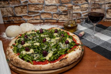 Brokoli, gorgonzola peyniri, siyah zeytin, sarımsak ve domates soslu pizza.