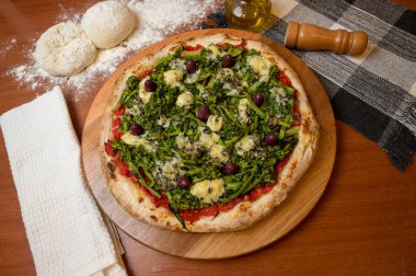 Brokoli, gorgonzola peyniri, siyah zeytin, sarımsak ve domates soslu pizza.