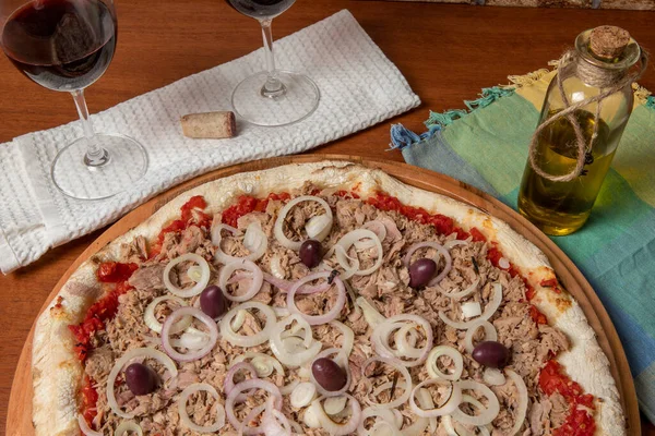 Pizza tuna fish, onion, tomato and black olive on wooden table. Traditional Brazilian Pizza.