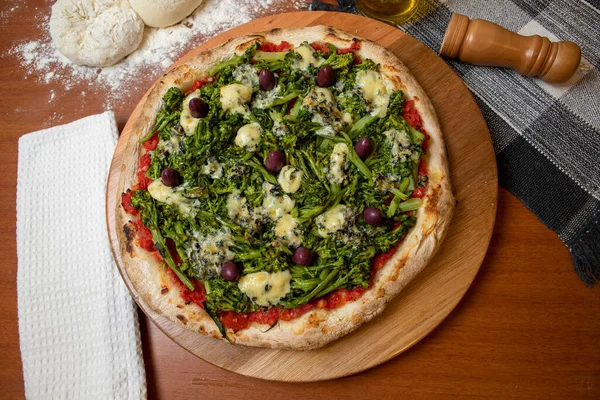 Brokoli, gorgonzola peyniri, siyah zeytin, sarımsak ve domates soslu pizza.