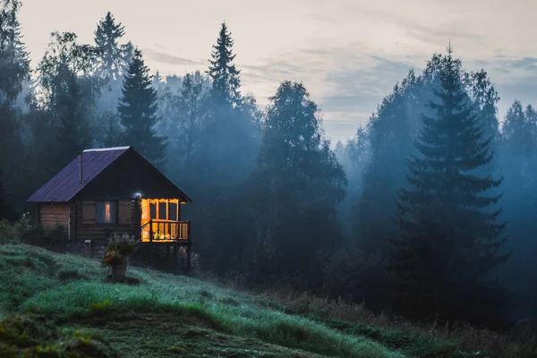 Pequeña casa de madera vieja en el bosque brumoso . — Foto de Stock