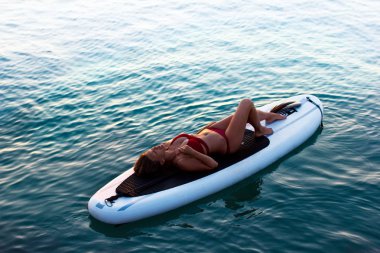 sörf tahtası üzerinde su dalgalanma yatan güzel genç kadın