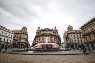Cenova, İtalya - 8 Nisan 2016. Cenova De Ferrari meydanının panoramik görünümü, merkezi çeşme ve Borsa sarayı ile şehrin kalbi. Piazza De Ferrari üzerinde çeşme pembe su
