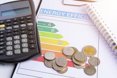 Enerji verimliliği kavramı ile enerji derecelendirme grafik ve madeni para, hesap makinesi
