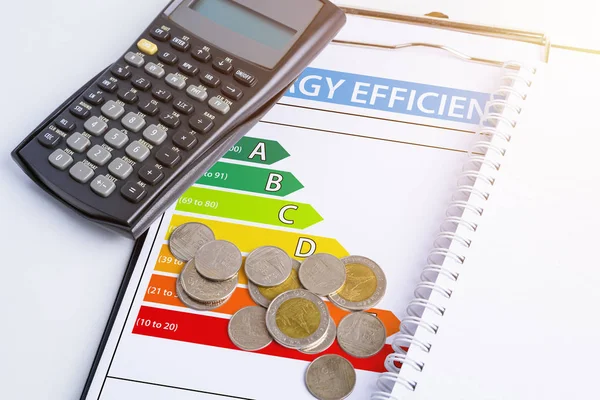 Enerji verimliliği kavramı ile enerji derecelendirme grafik ve madeni para, hesap makinesi