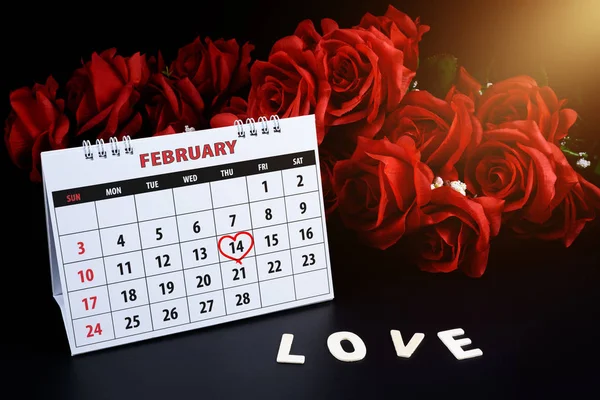Calendar with red written heart highlight on February 14 of Saint Valentines day with Wooden letters word \