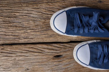 Üstten görünüm bir çift mavi tuval Ayakkabı kopya alanı ile ahşap arka plan üzerinde. Vintage etkisi.