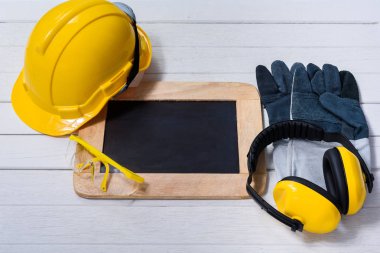 Standart inşaat güvenlik ekipmanları ile beyaz ahşap arka plan boş tahta. Emanet ilk kavramlar