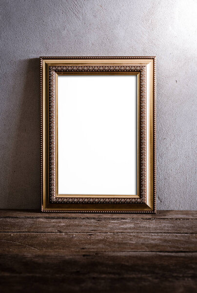Still life of luxurious photo frame on wooden table over grunge background. vintage tone