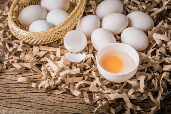 Natürmort ördek yumurta ve saman kağıt ve grunge ahşap arka plan üzerinde bir kasede yumurta sarısı