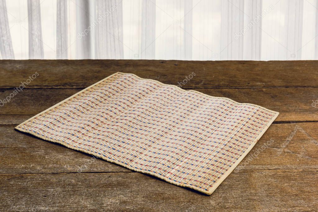 The Coaster, Dark brown bamboo mat on wooden background